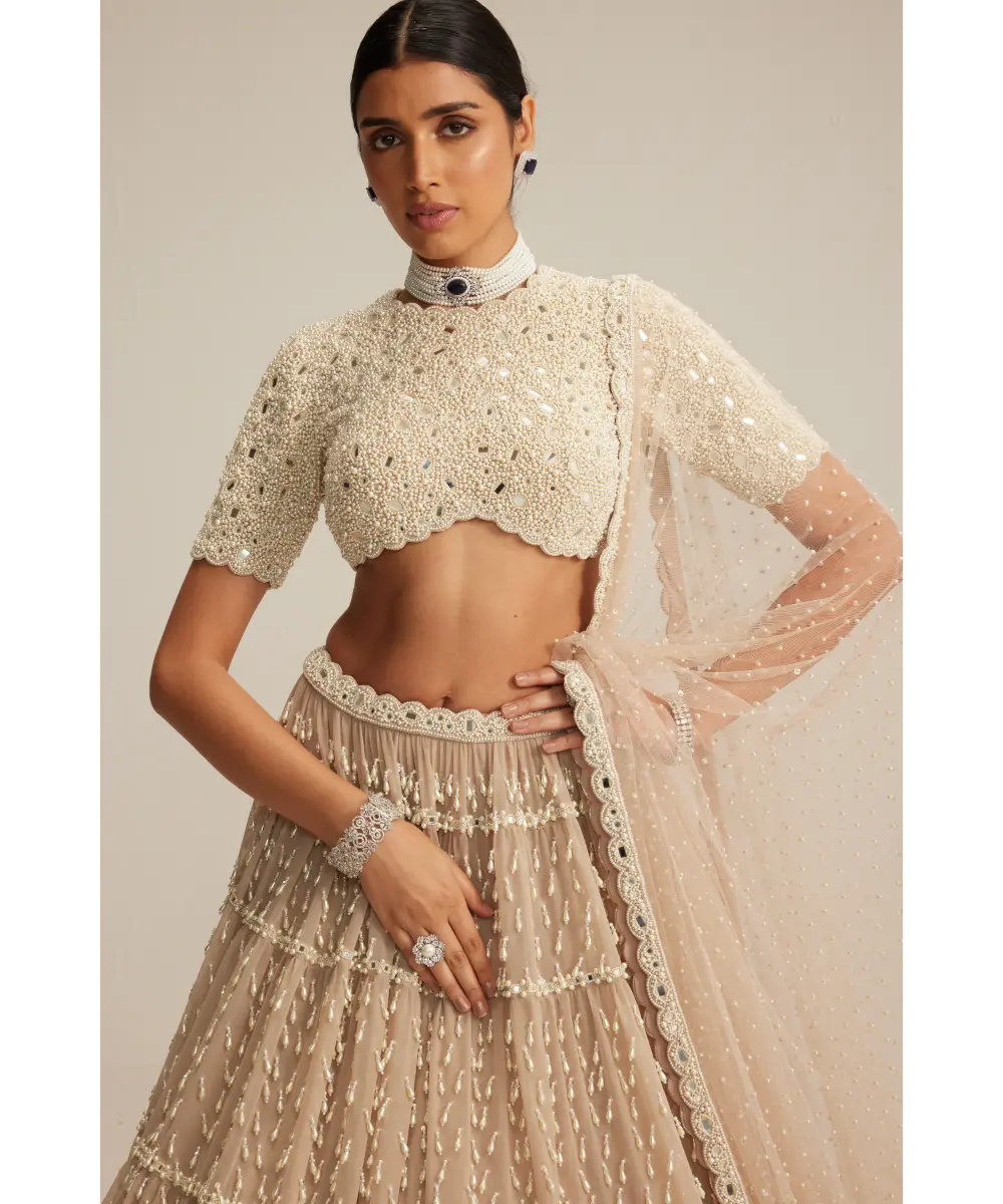 VVANI VATS- Light Beige Pearl Drop Multi Tier Lehenga With High Neck Blouse Set.